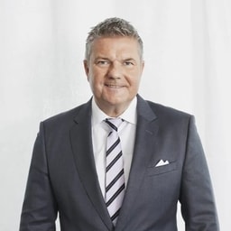 Confident Businessman in Gray Suit and Striped Tie Portrait Professional man in a dark suit with a striped tie and white pocket square on white background.