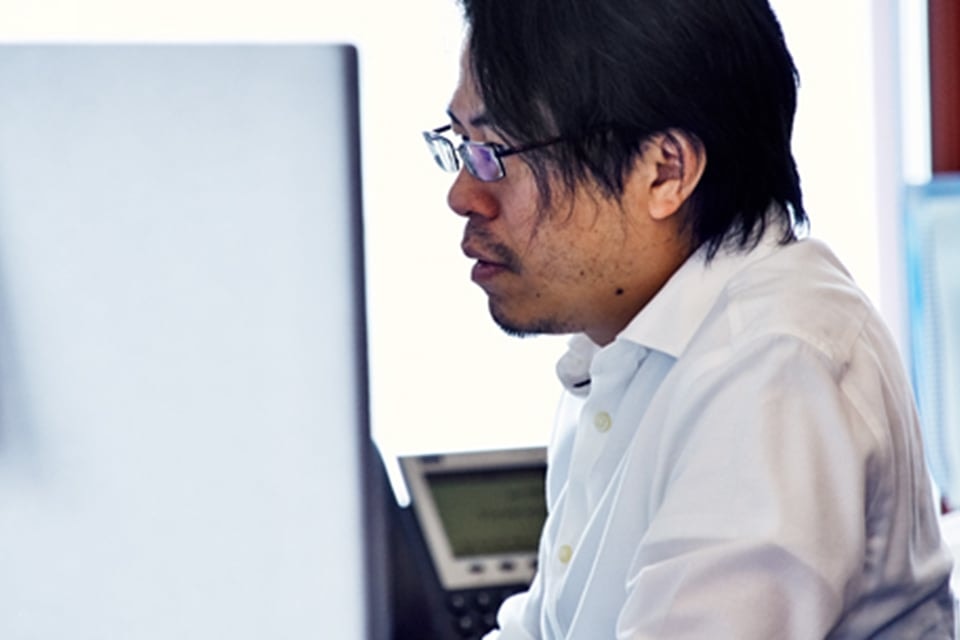 Man working at a computer in an office environment, focused and professional.