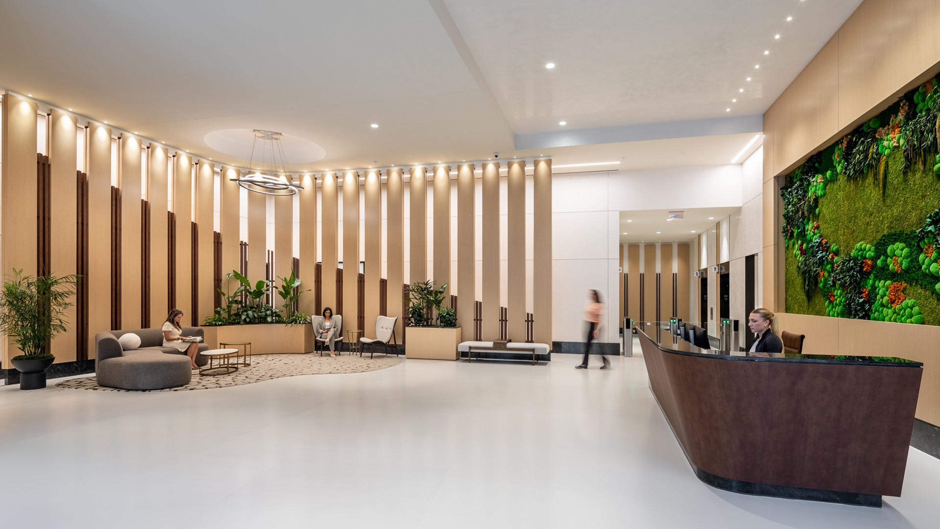 3091 office lobby with stylish reception desk, seating area, and vertical plant wall.