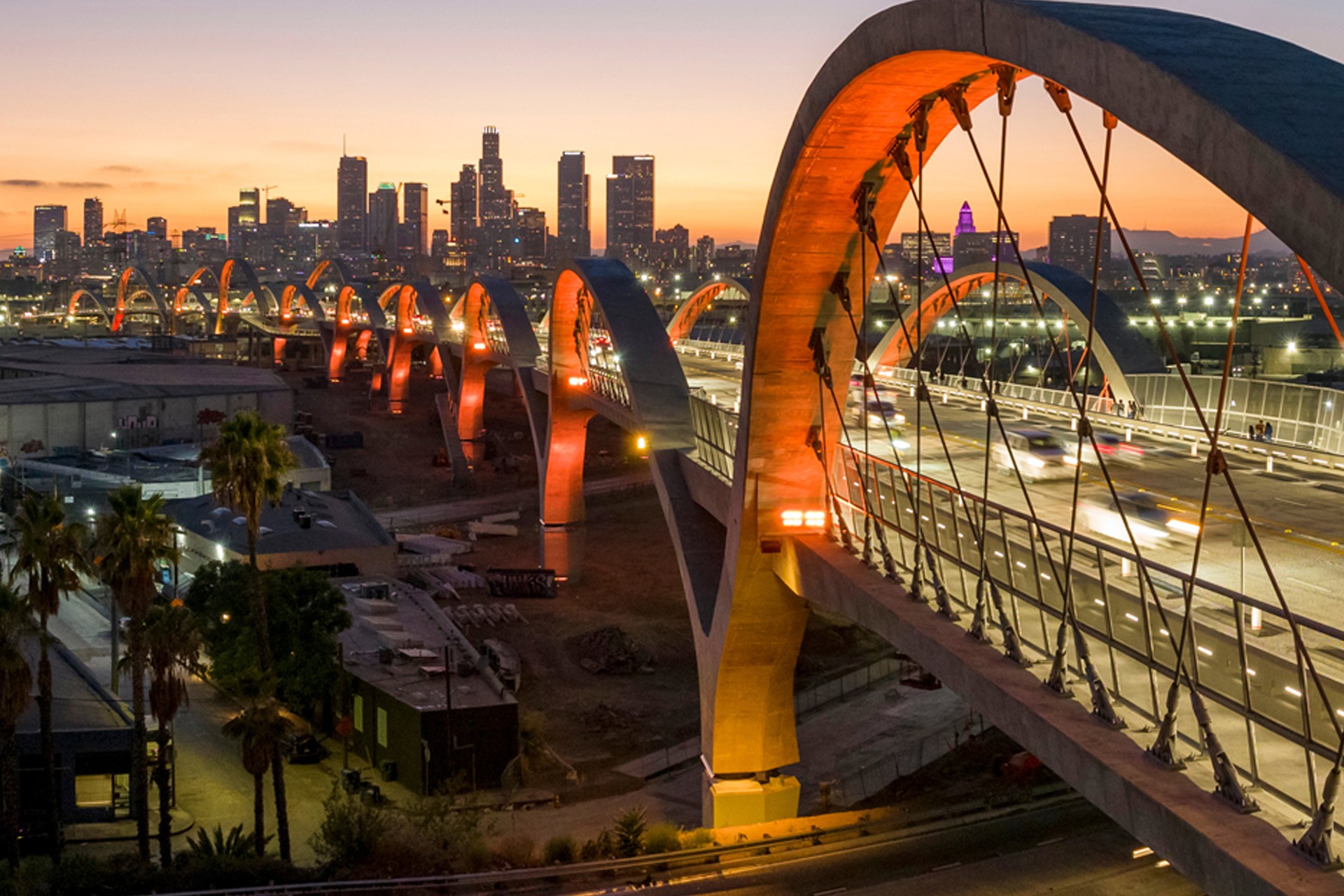 Los Angeles skyline at dusk with illuminated Sixth Street Bridge Evening view of the illuminated Sixth Street Viaduct bridge with downtown Los Angeles skyline.
