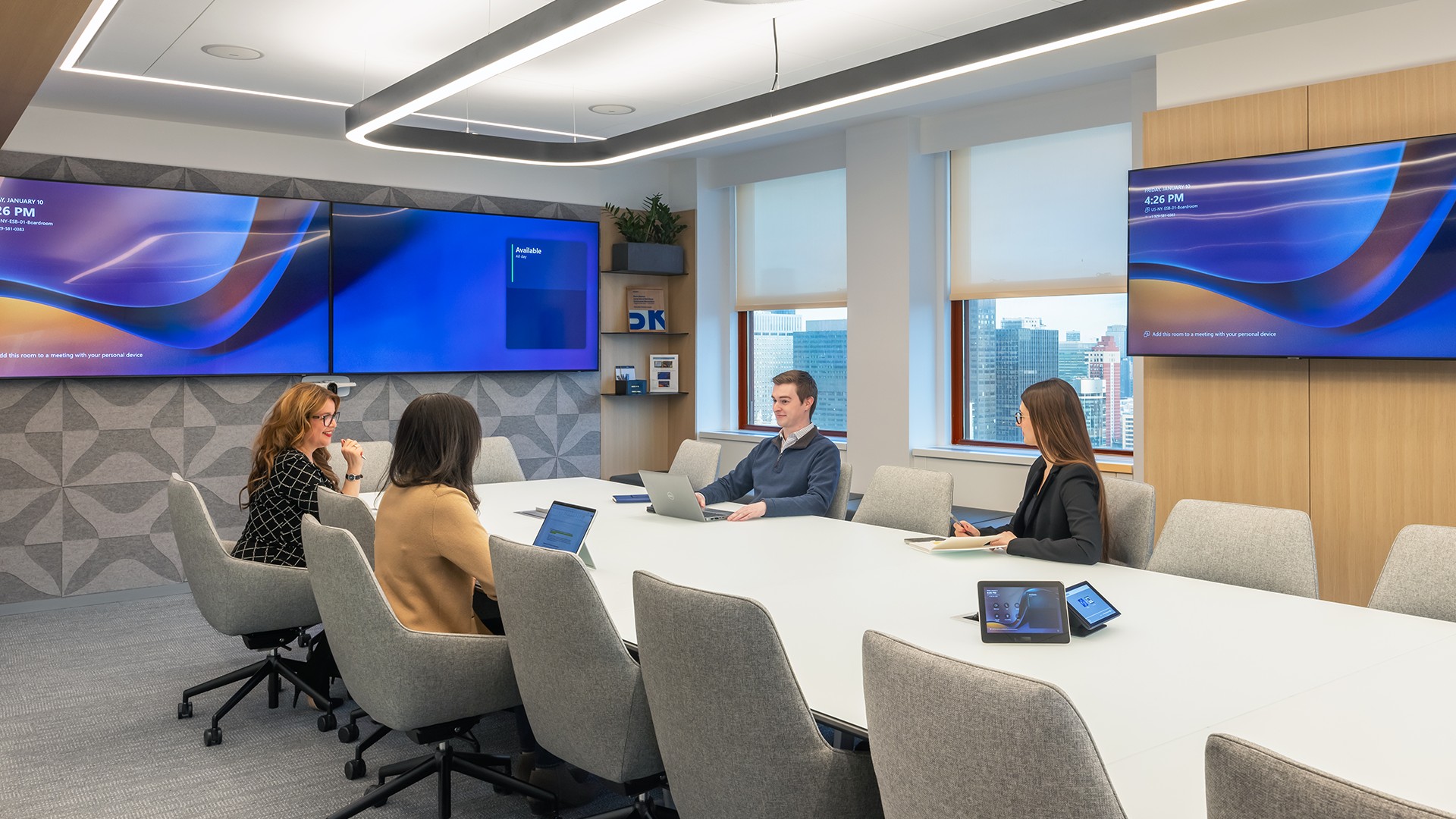 Modern Office Meeting with Team and Technology Screens ESB meeting room with four professionals collaborating and digital screens.