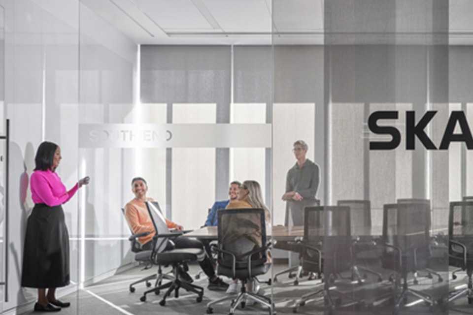 Business team holding a meeting in a glass office conference room.