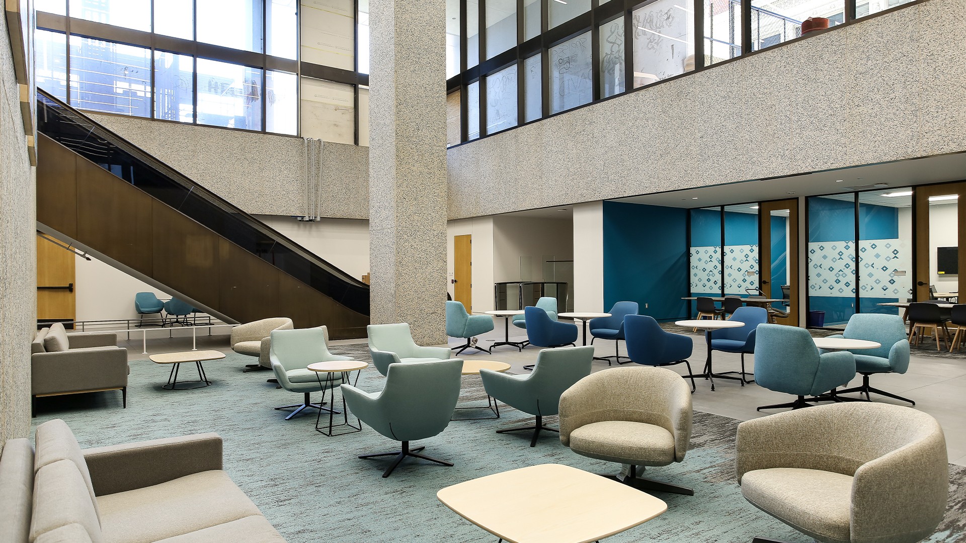 Government Building Exterior with Clear Blue Sky Modern government building lounge with blue and beige chairs, tables, and large windows.