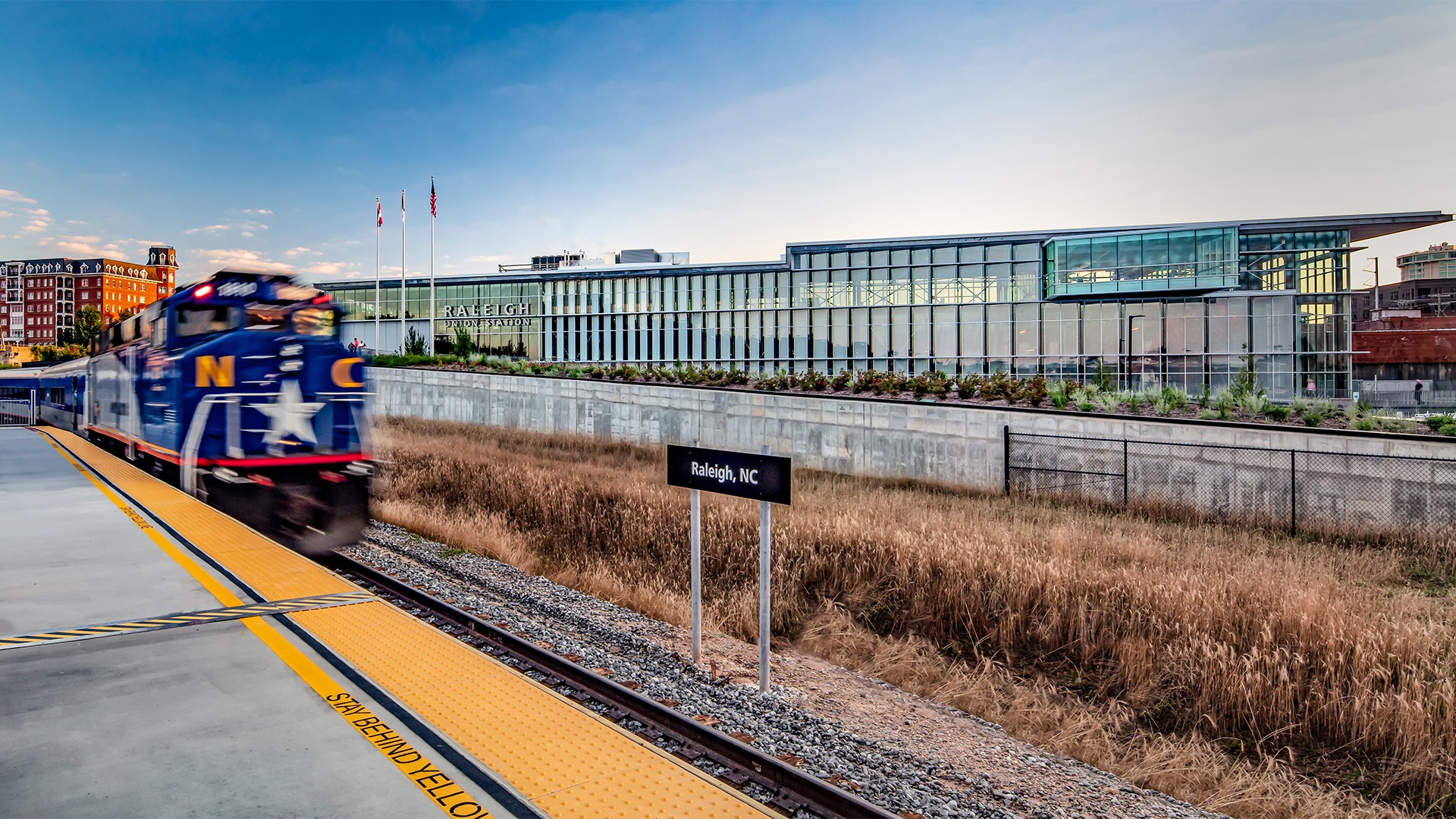 Government Building Exterior with Clear Blue Sky A North Carolina train arriving at Raleigh, NC station with modern building background.