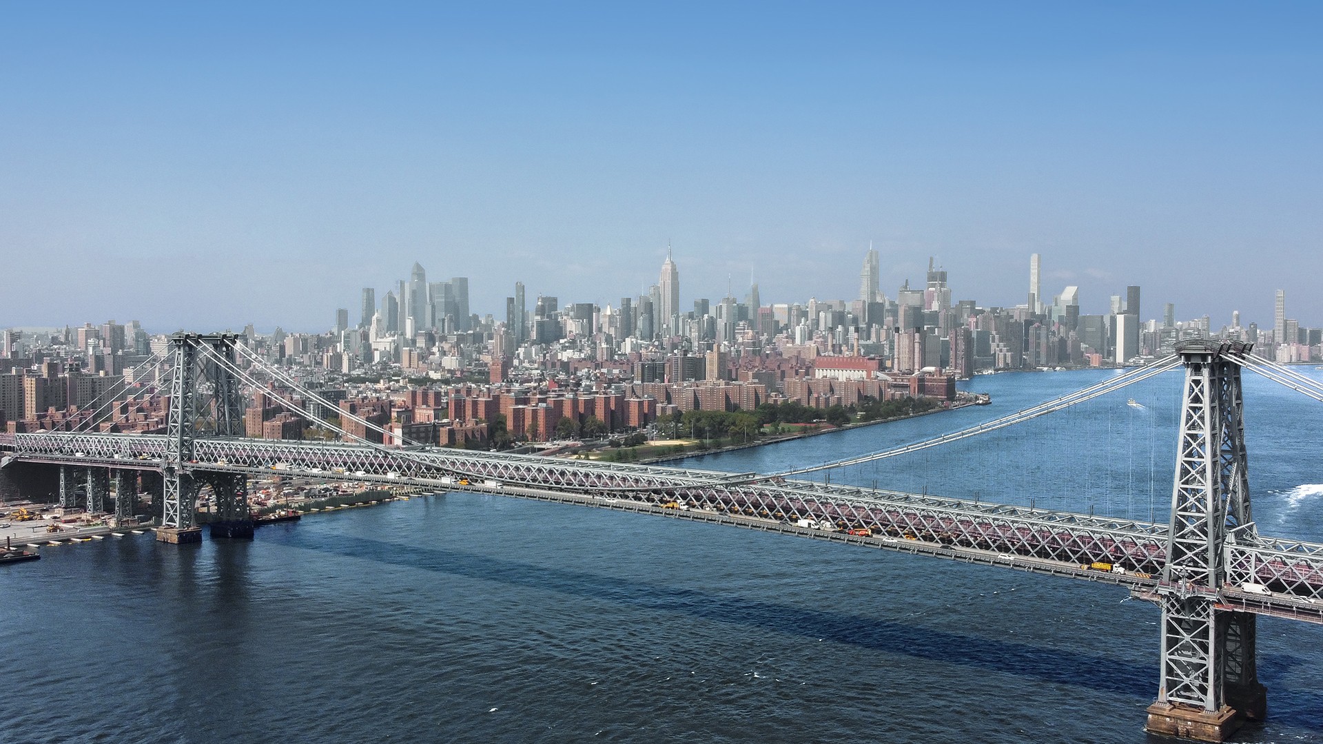 Brooklyn Bridge with Manhattan Skyline in Clear Daylight View of the Williamsburg Bridge over the East River with New York City skyline in background.