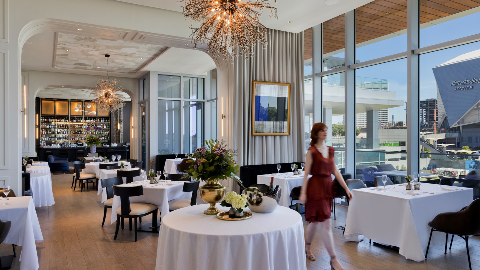 Hotel Lounge with Panoramic Window Views Woman walking through a decorated hotel restaurant lounge