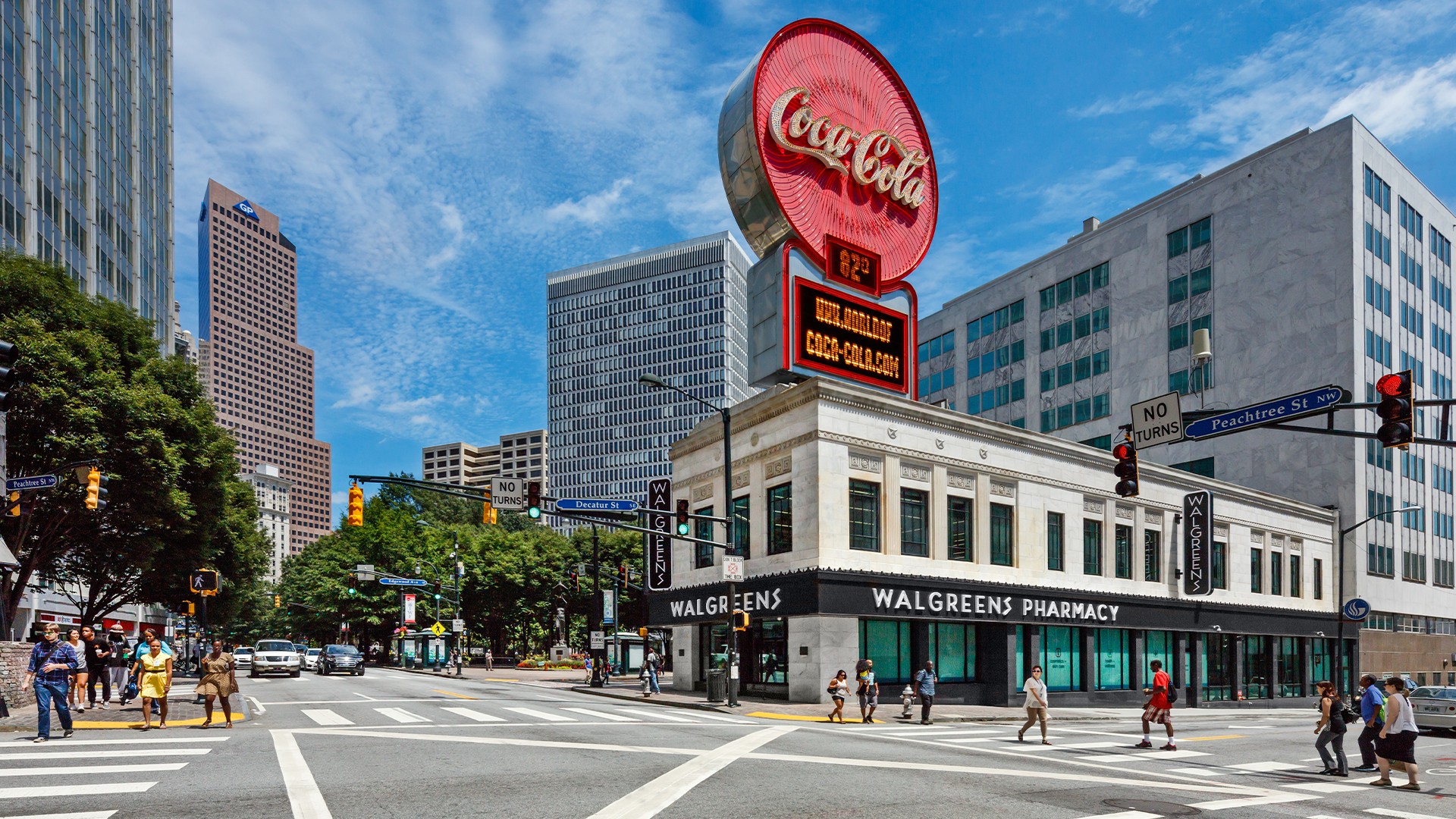 Office Lobby with Stylish Seating and Wooden Accents Exterior shot of a building on a busy street with a big "Coca Cola" and "Walgreens Pharmacy" sign
