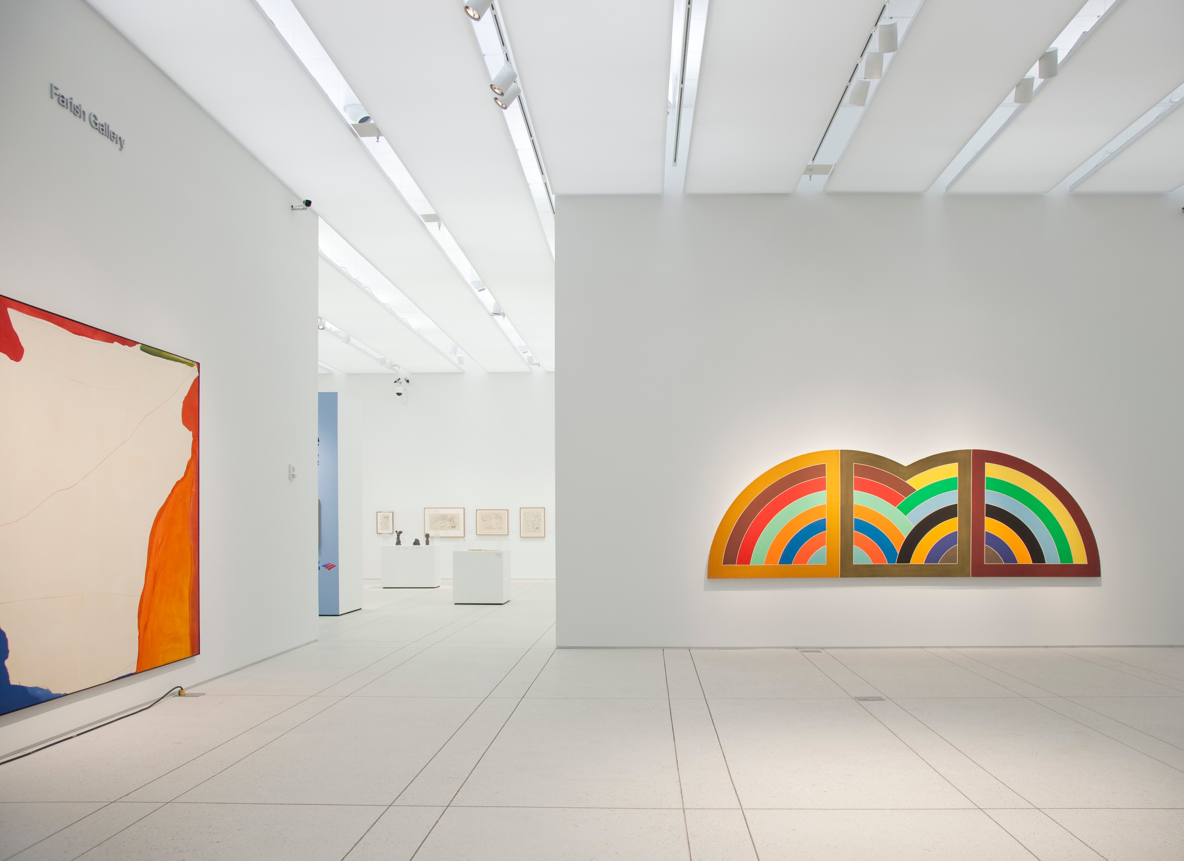 Modern art gallery featuring colorful abstract paintings with geometric designs on white walls.