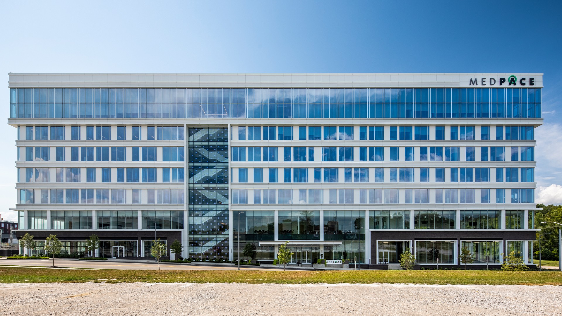 Laboratory with Advanced Equipment and Workspace Modern MEDPACE office building with large glass windows and clear blue sky background.