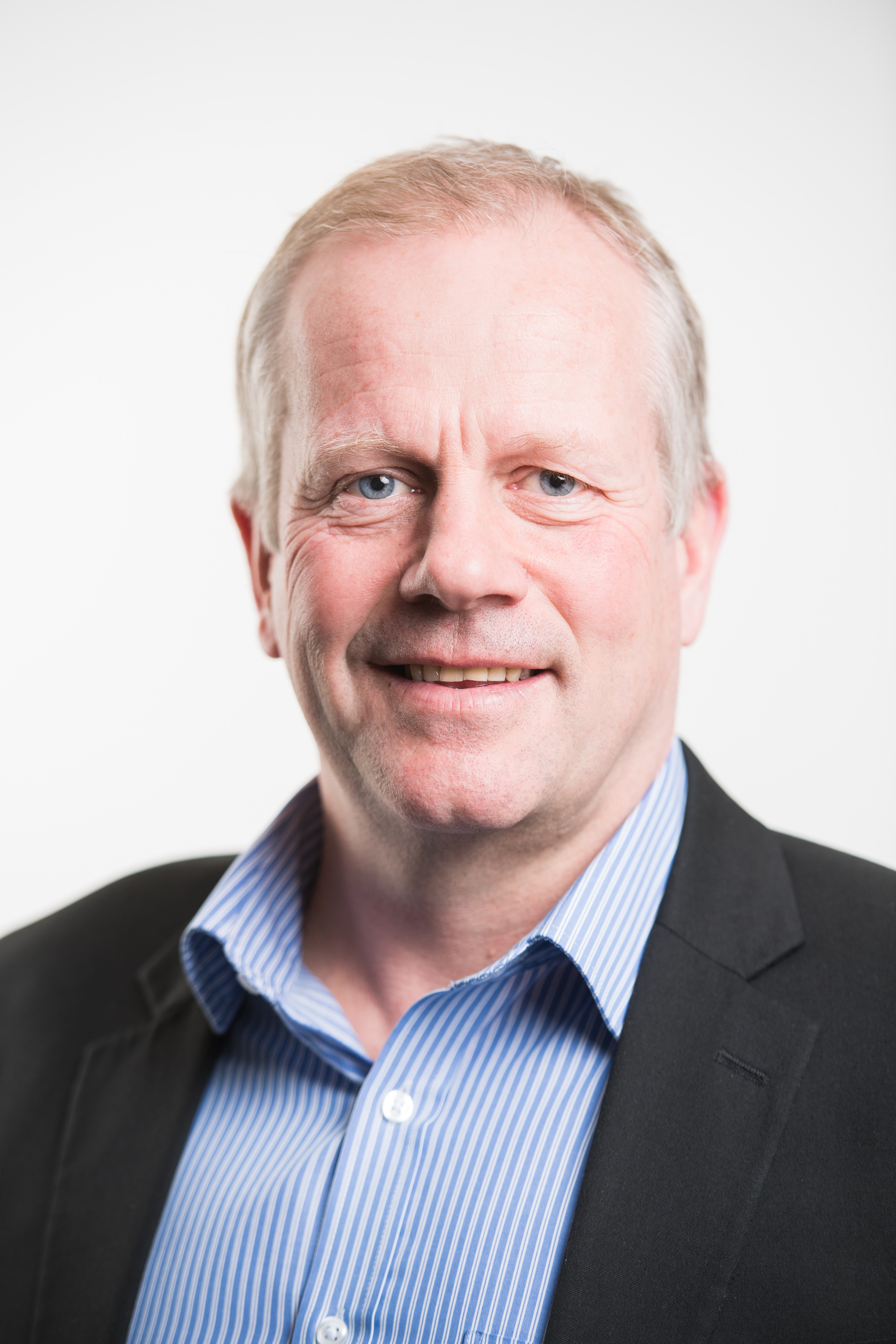 Mick Davidson Portrait photo of man wearing a blue shirt and black jacket.