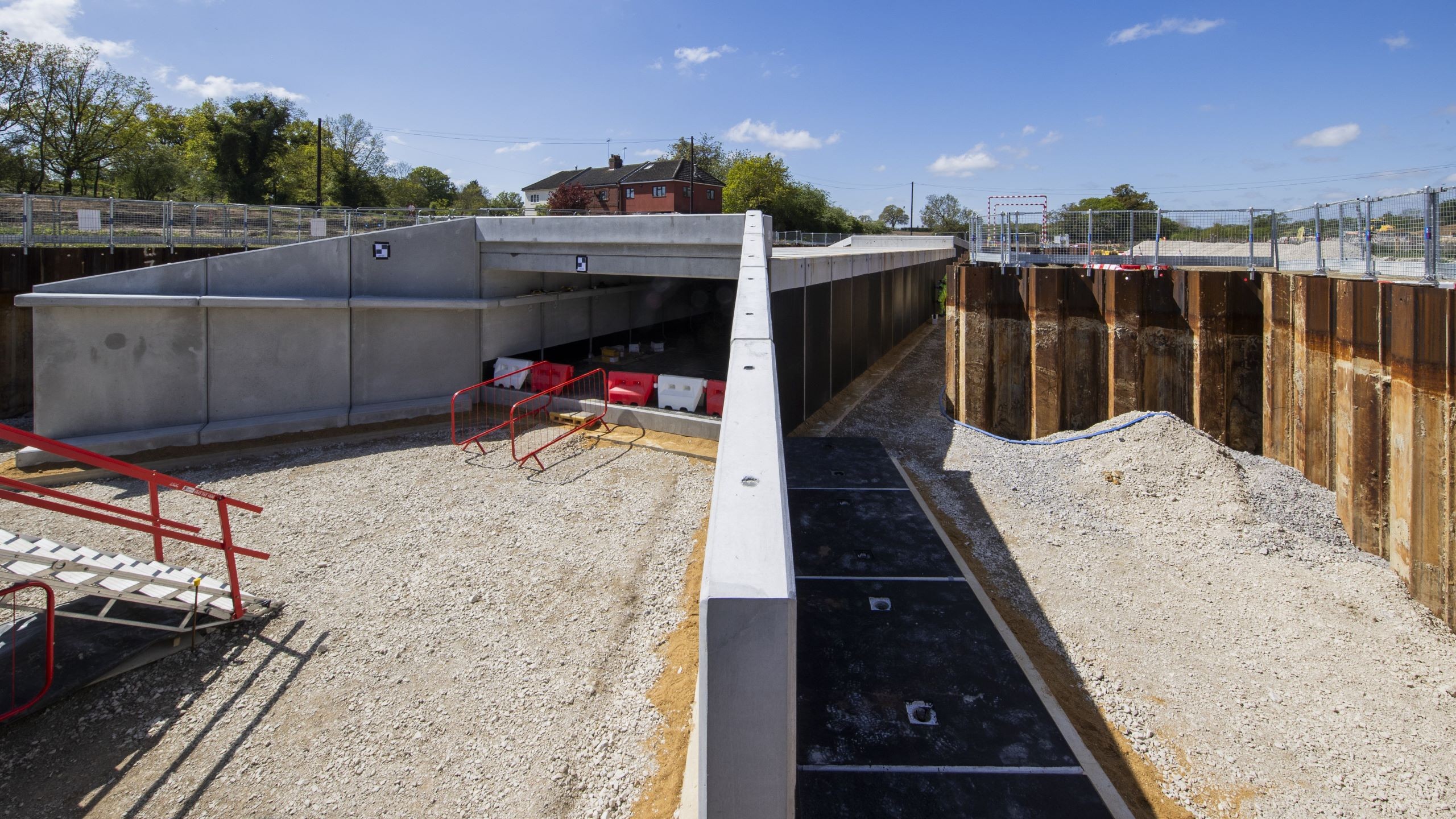 Construction site of a modern concrete underpass with clear blue sky background.