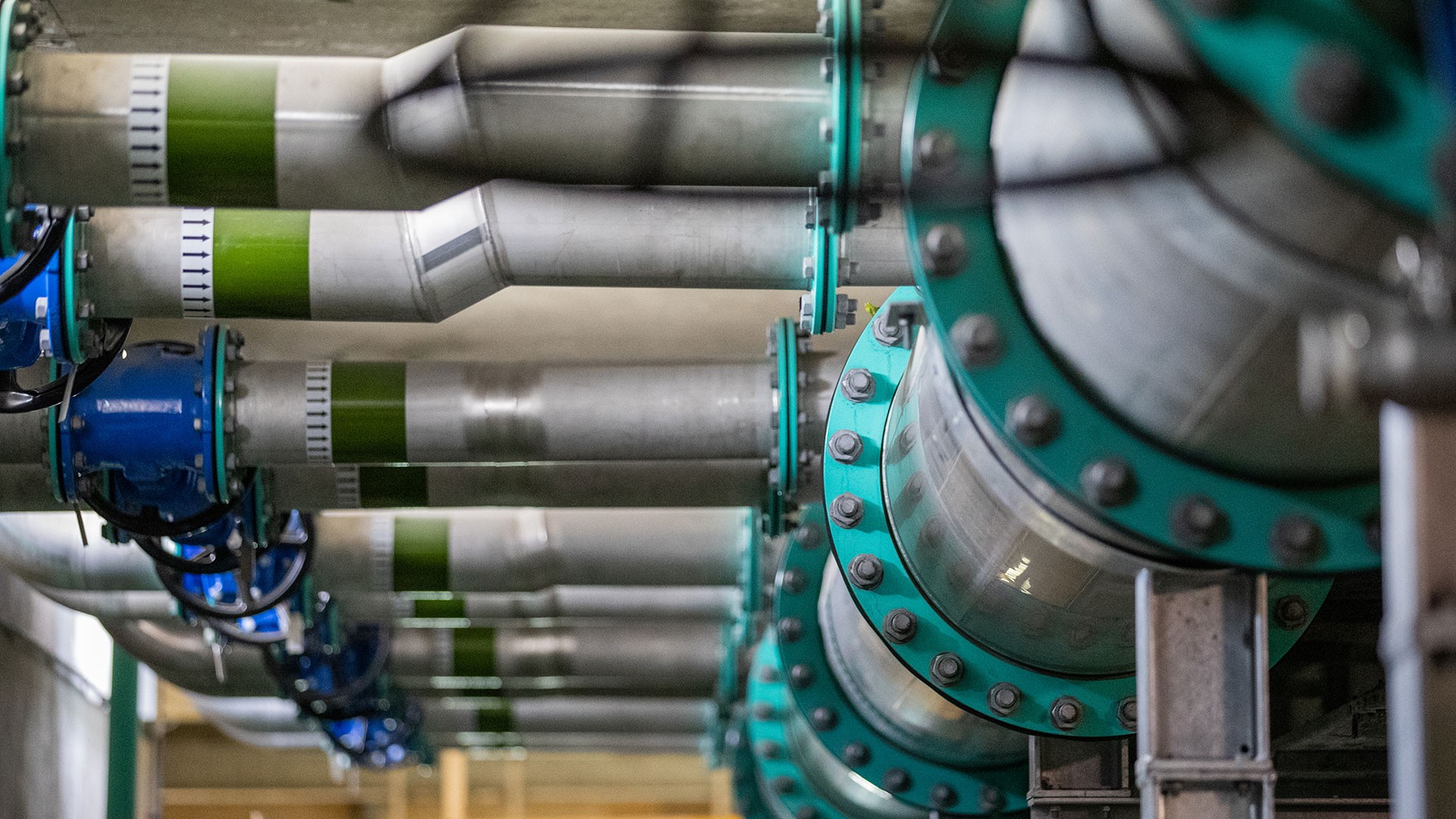 Anglian Water @one Alliance Large industrial pipes with green and blue valves in a water treatment facility.