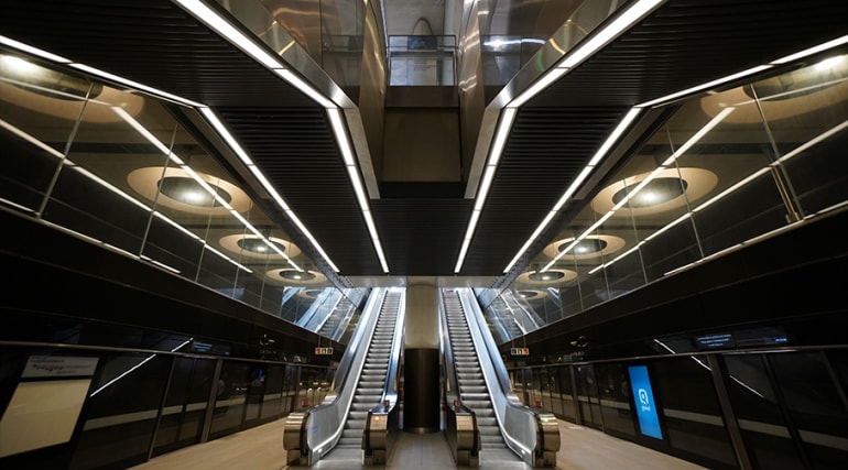 Modern subway station with sleek escalators and futuristic design elements.