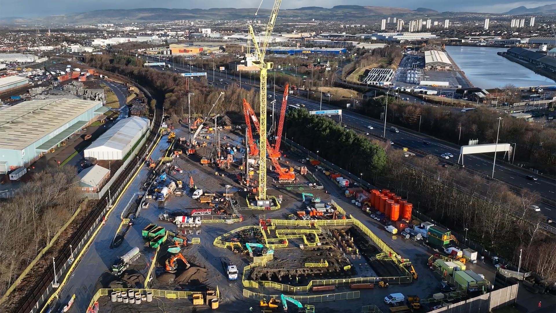 Arial view of South Clyde Energy Centre site Aerial view of a bustling construction site with cranes, machinery, and industrial buildings nearby.