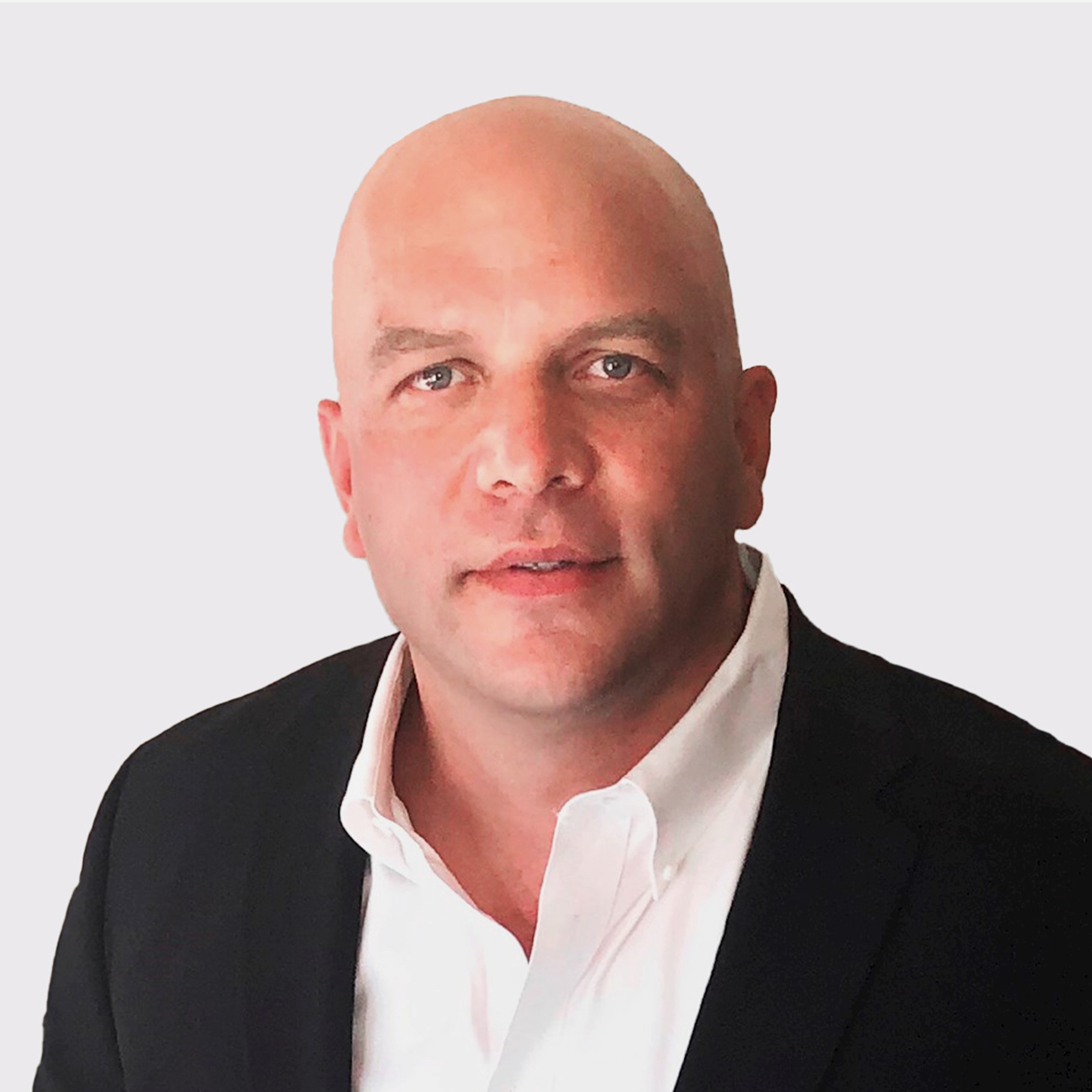 Professional Man in Suit Against Neutral Background Brad in a suit and white shirt against a light background
