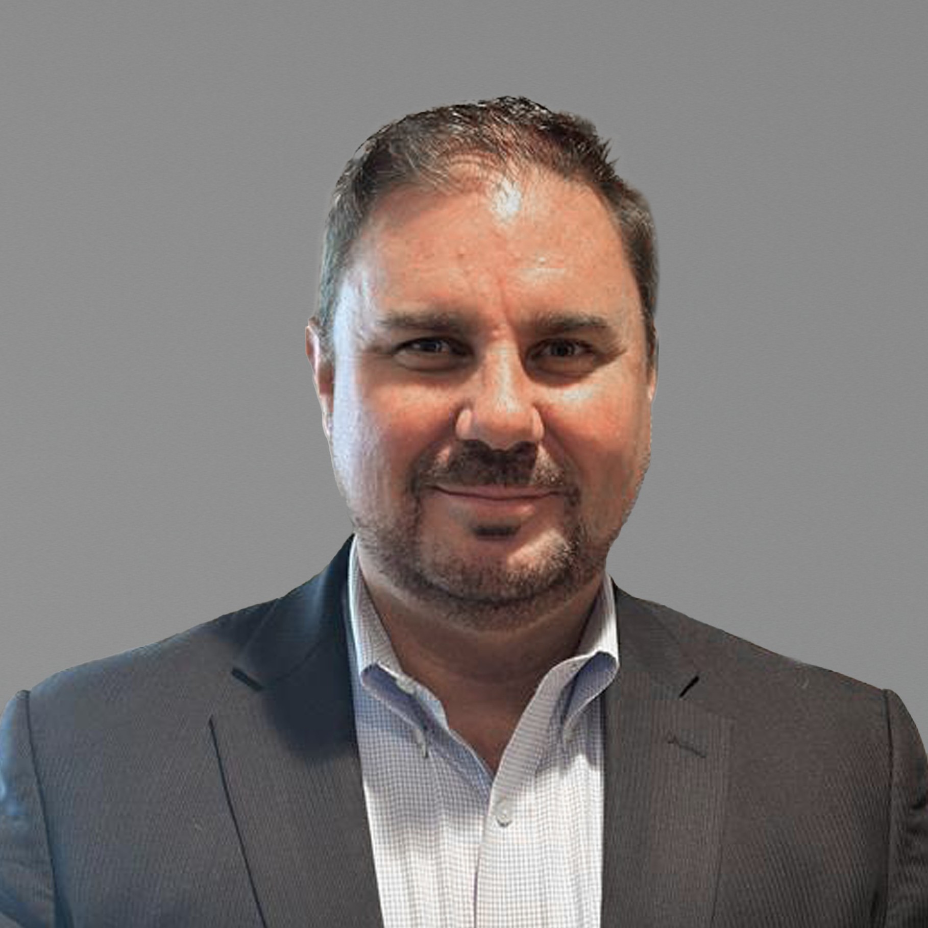 Professional businessman in suit with gray background portrait Stephen in a dark suit jacket and light checkered shirt with gray background.