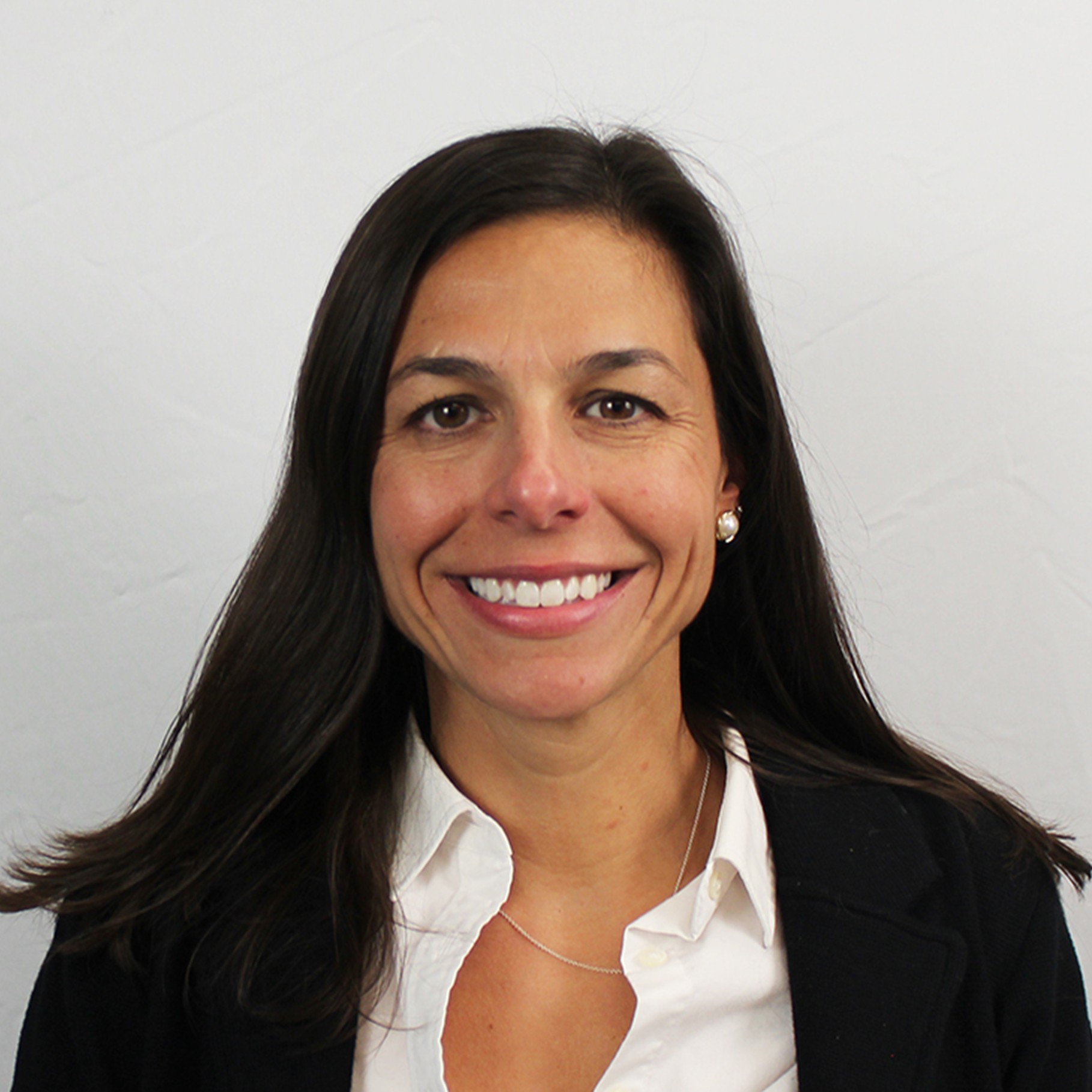 Professional woman with long dark hair in white shirt and blazer Professional woman with long dark hair wearing a white shirt and black blazer.