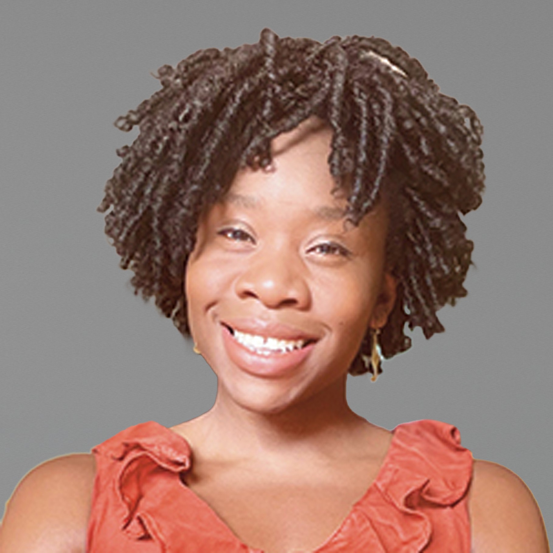 Stylish Twists Hairstyle with Elegant Coral Dress A person wearing a coral ruffled top has short, curly hair in a home setting with soft lighting.