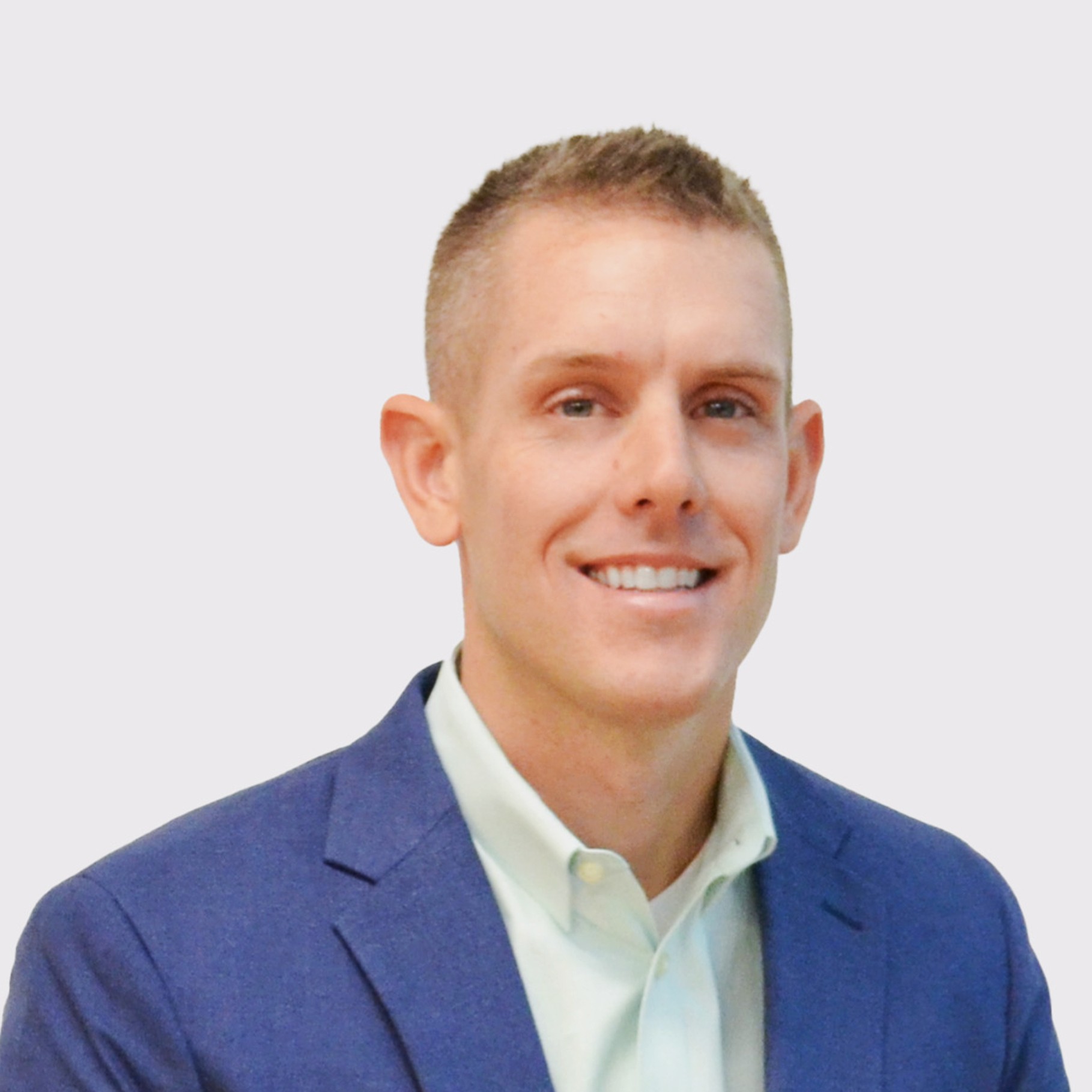 Professional Man in Blue Suit and Light Shirt A person in a blue suit jacket and light-colored shirt against a plain background.