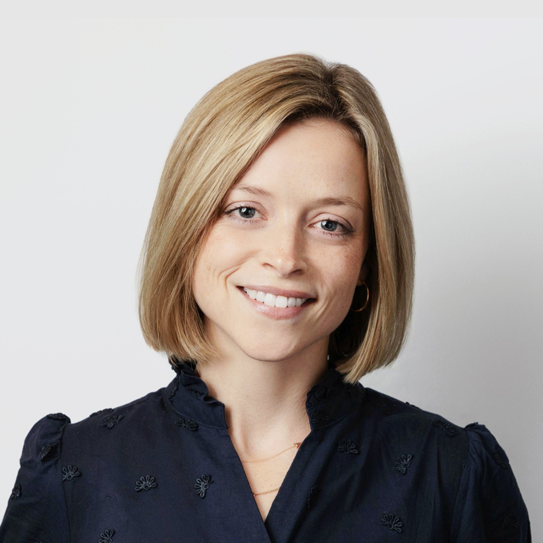 Michelle Santoro wearing a navy blouse with embroidered details.