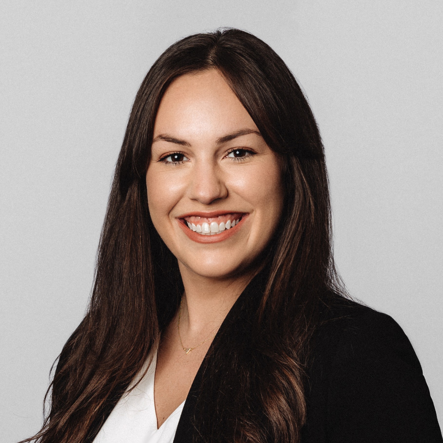 Professional woman with long dark hair in business attire Professional woman with long dark hair wearing a black blazer and white blouse.