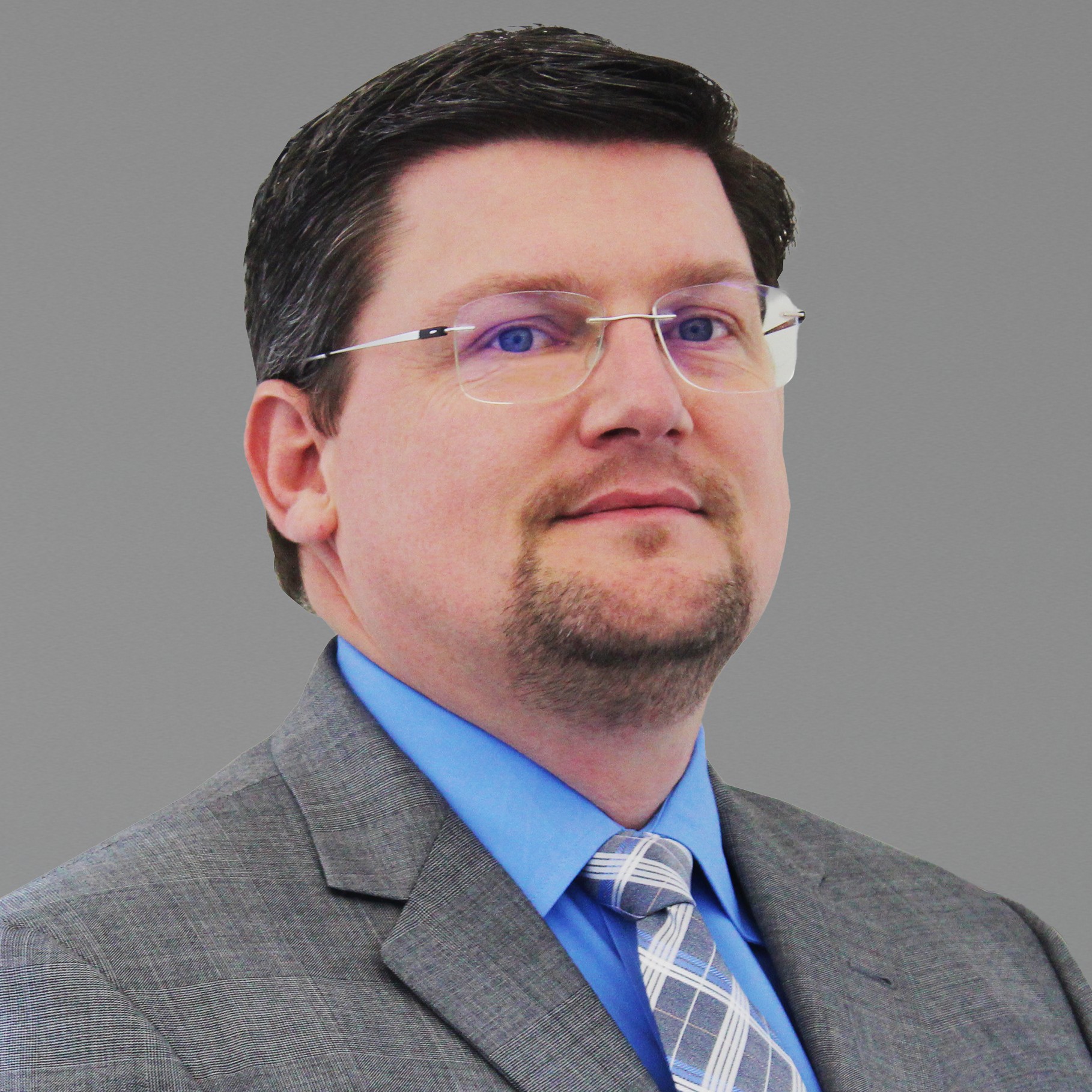 Professional man in gray suit and blue shirt with tie portrait Professional man in gray suit and blue shirt with patterned tie against gray background.