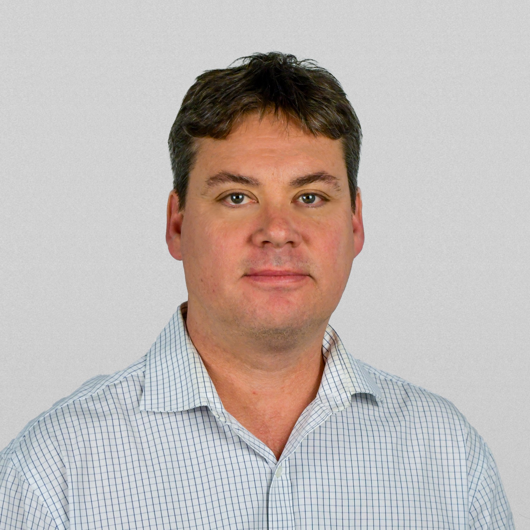 Professional man in checkered shirt on gray background portrait Man wearing a white checkered dress shirt against a plain gray background.
