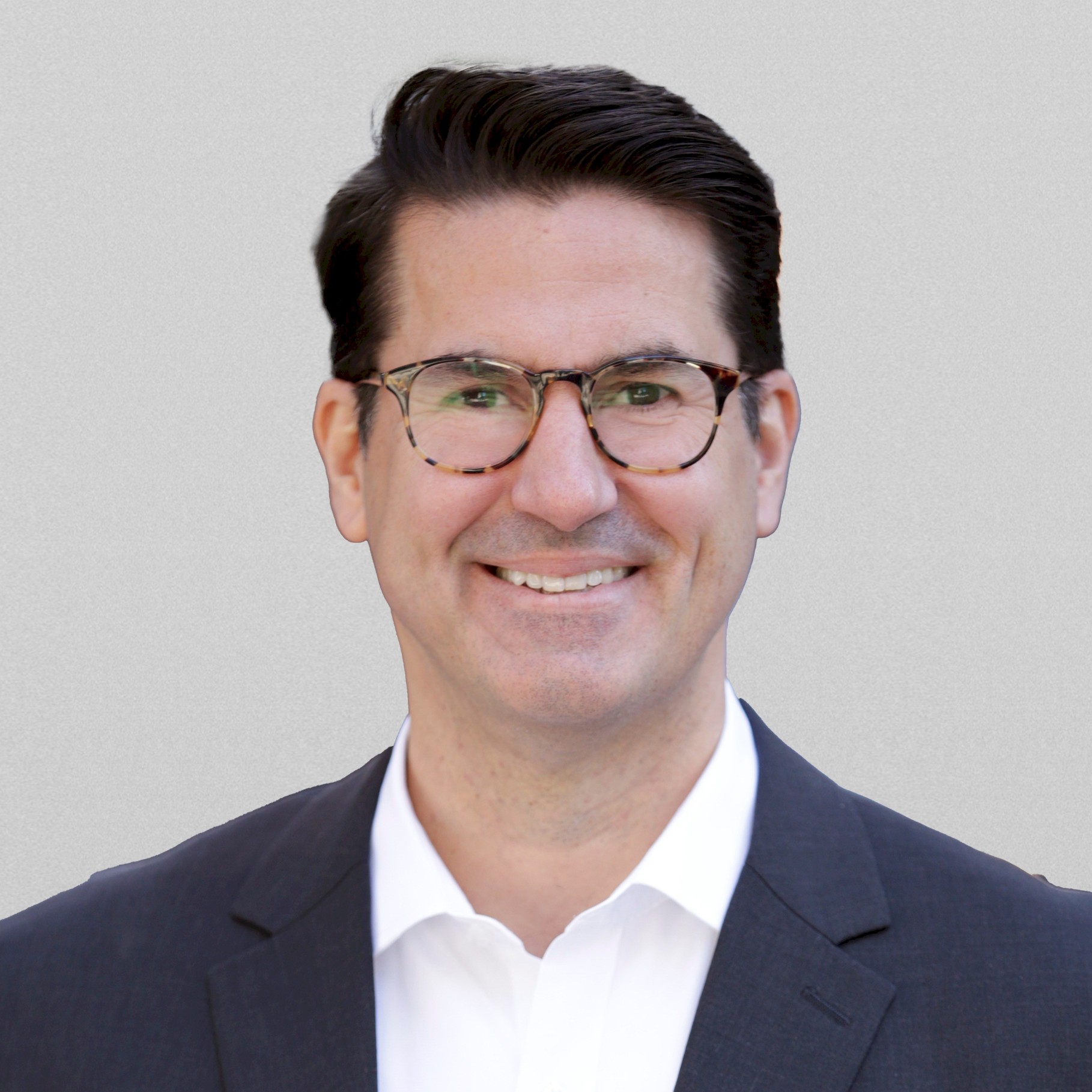 Professional man in business suit with white shirt, gray background Professional man in dark suit and white shirt with blurred face on gray background.
