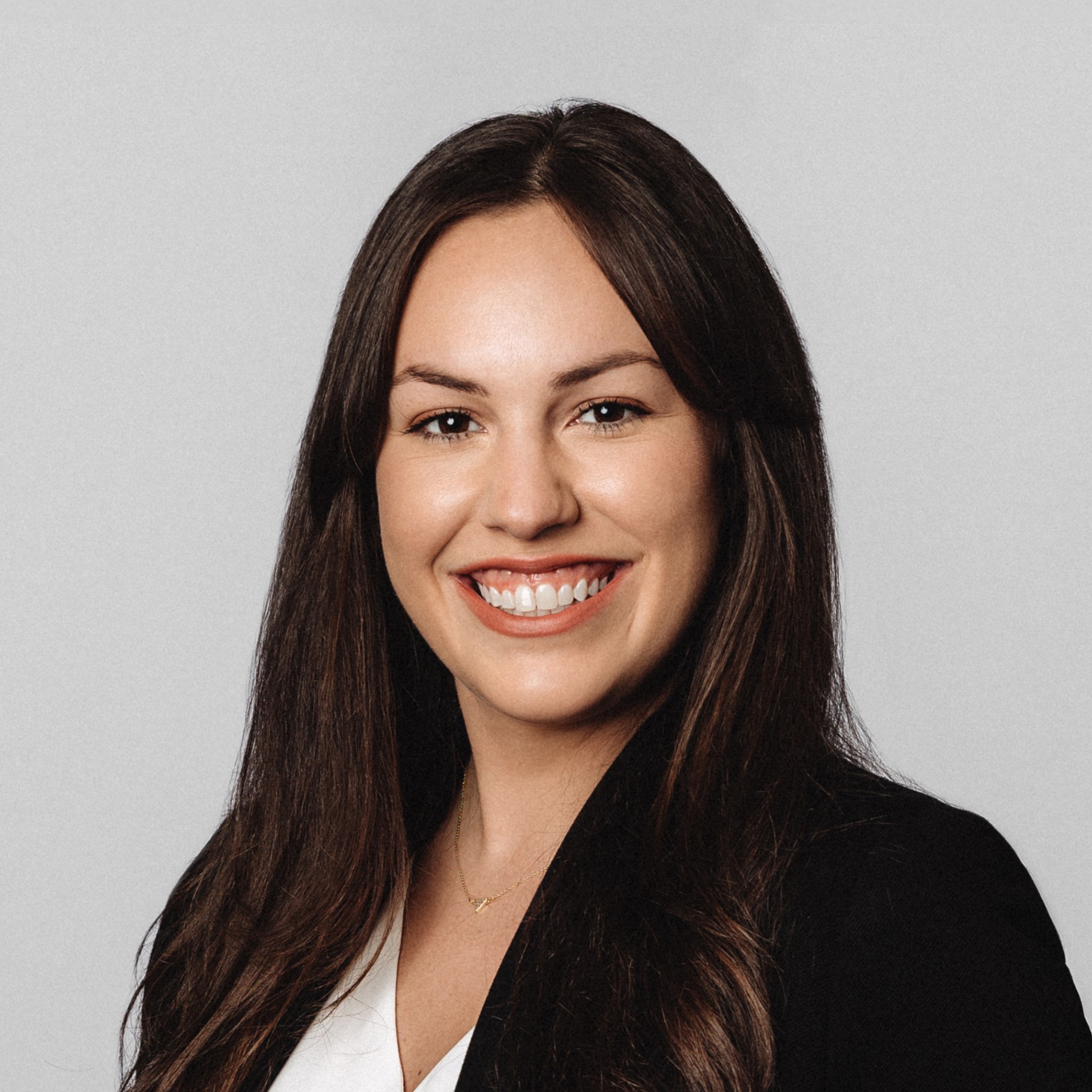 Professional woman with long dark hair in business attire Professional woman with long dark hair wearing a black blazer and white blouse.