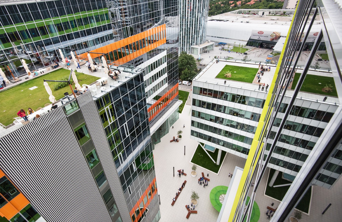 Green Court Bucharest courtyard Modern office complex with vibrant colors and rooftop gardens, viewed from above.
