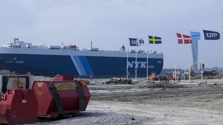 Norra Hamnen A large NYK Line cargo ship docked near construction site, with flags of Sweden and Denmark visible.