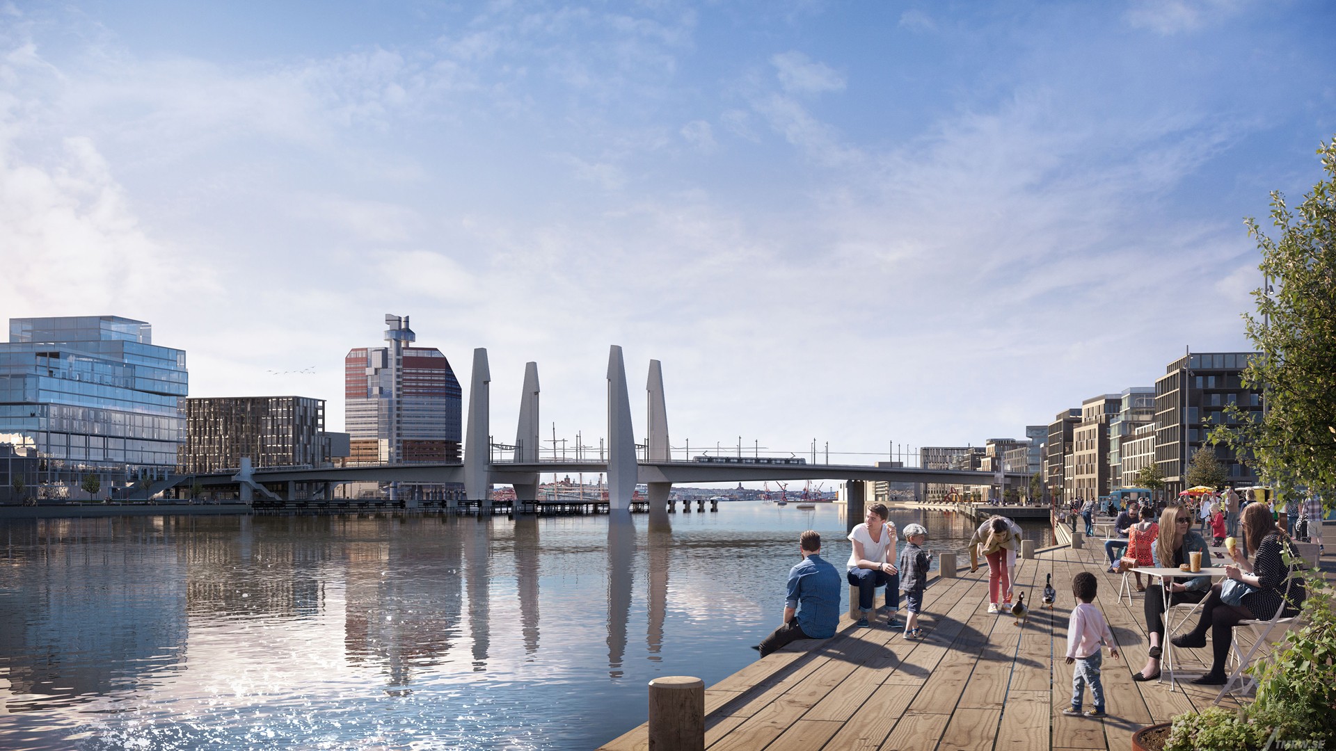 Modern waterfront with people relaxing, a bridge, and cityscape in the background under a clear sky.