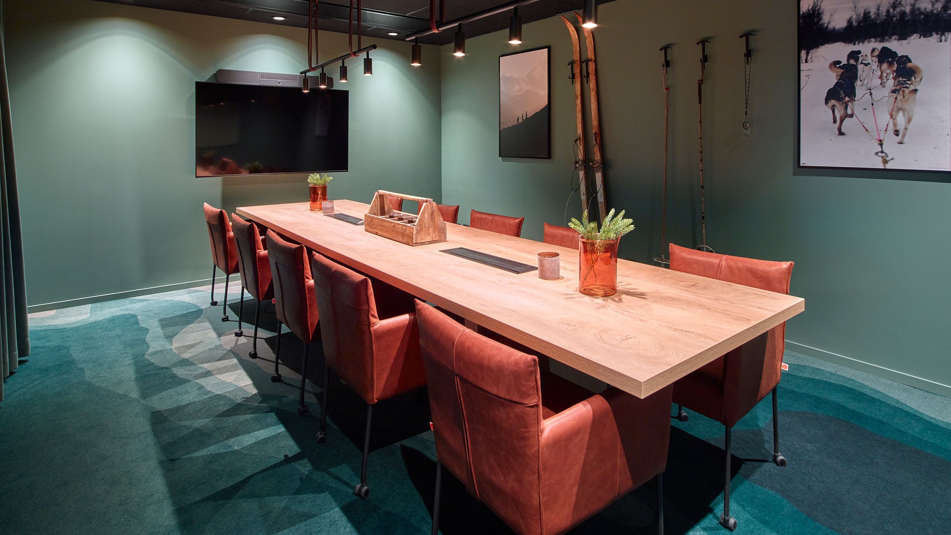 The boardroom in earthy tones and skis on the wall.