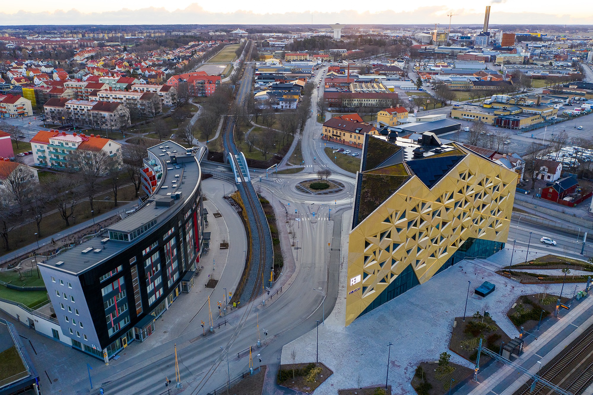 Aerial view of modern architecture featuring a uniquely designed building in an urban setting.