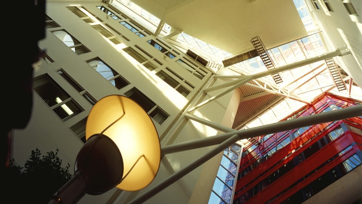 Modern atrium with geometric architecture, white walls, and bright natural lighting.