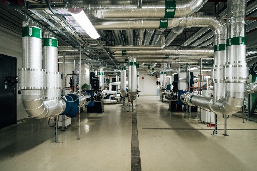 A modern industrial facility with extensive piping and ventilation systems in a clean setting.