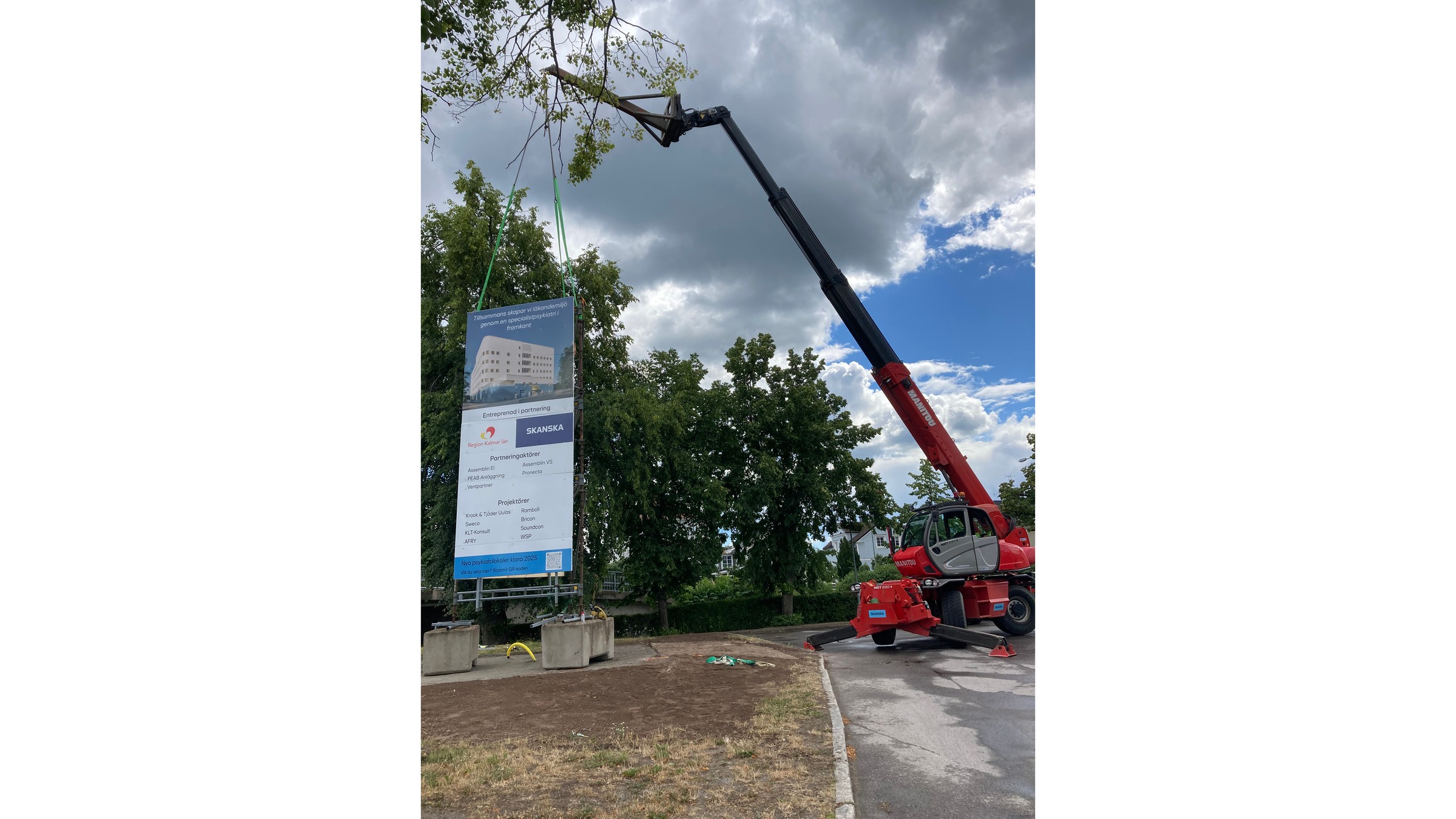 An information sign is lifted into place by a crane.