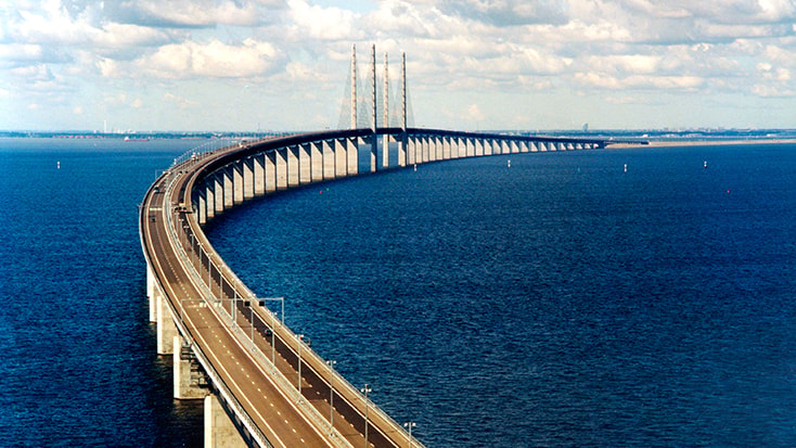 The Öresund Bridge Aerial view of the Øresund Bridge spanning across blue waters, connecting Sweden and Denmark.