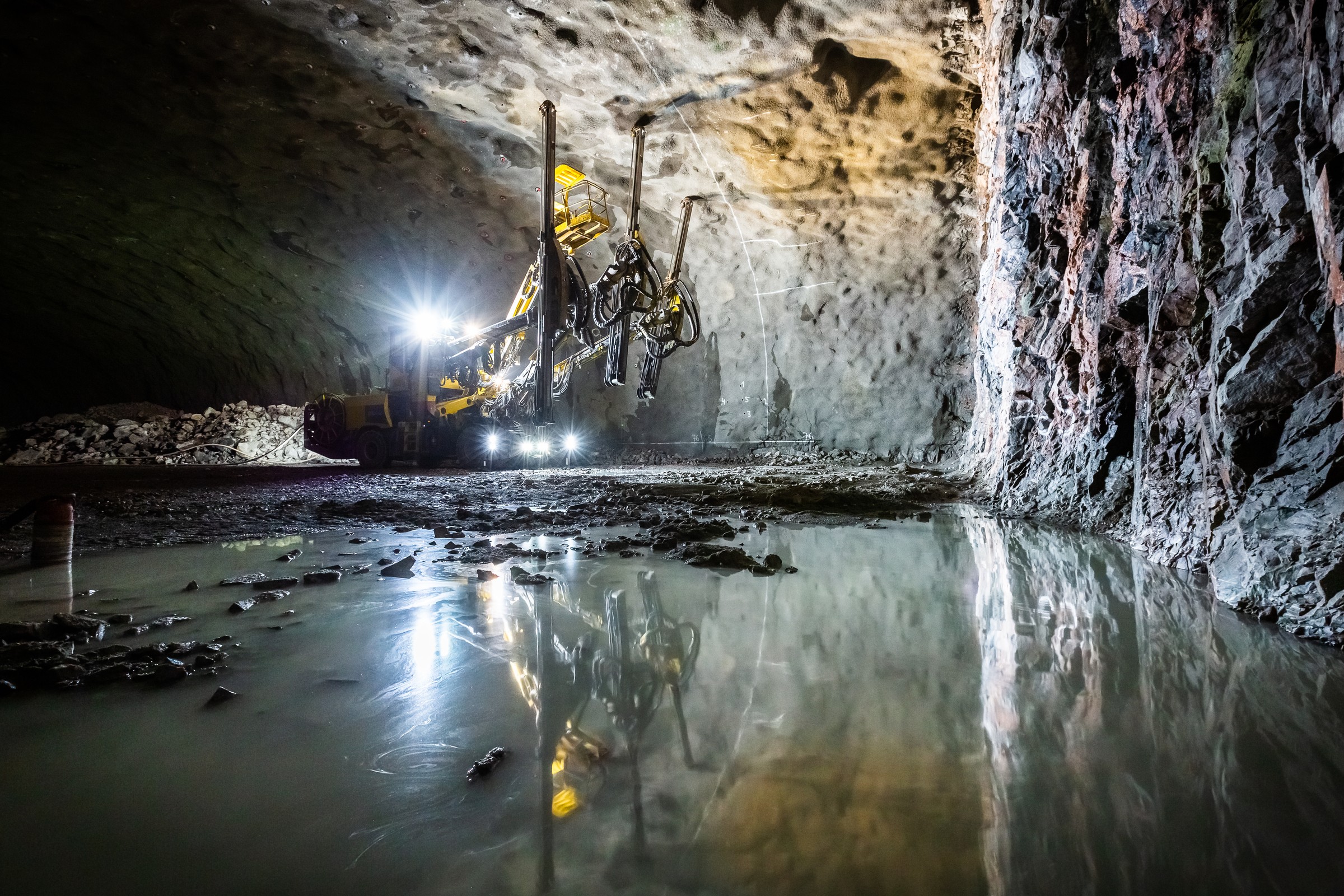 Skanska has found a way to reuse the process water in the tunnels. It is centrifuged to remove sand and fine rock particles, and can be reused in the tunnel boring machines. Rock and water in the foreground. The drilling rig Charlotta at work in the background.