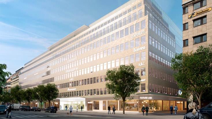Modernes mehrstöckiges Bürogebäude mit Glasfassade und Geschäften auf Straßenebene, in städtischer Umgebung gelegen.