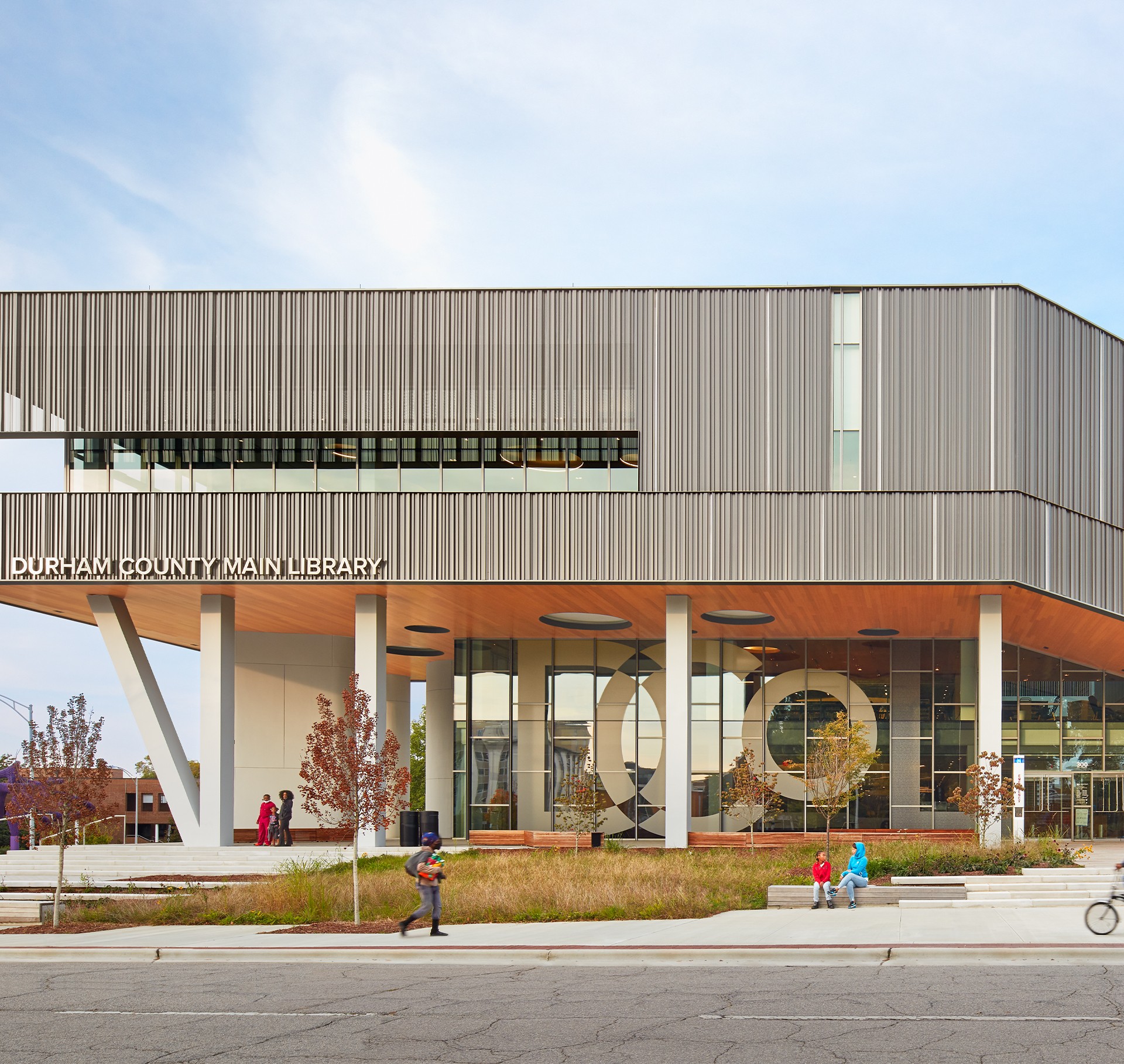 Durham County Main Library Modern Architecture Exterior View Modern Durham County Main Library building with glass facade and people outside.