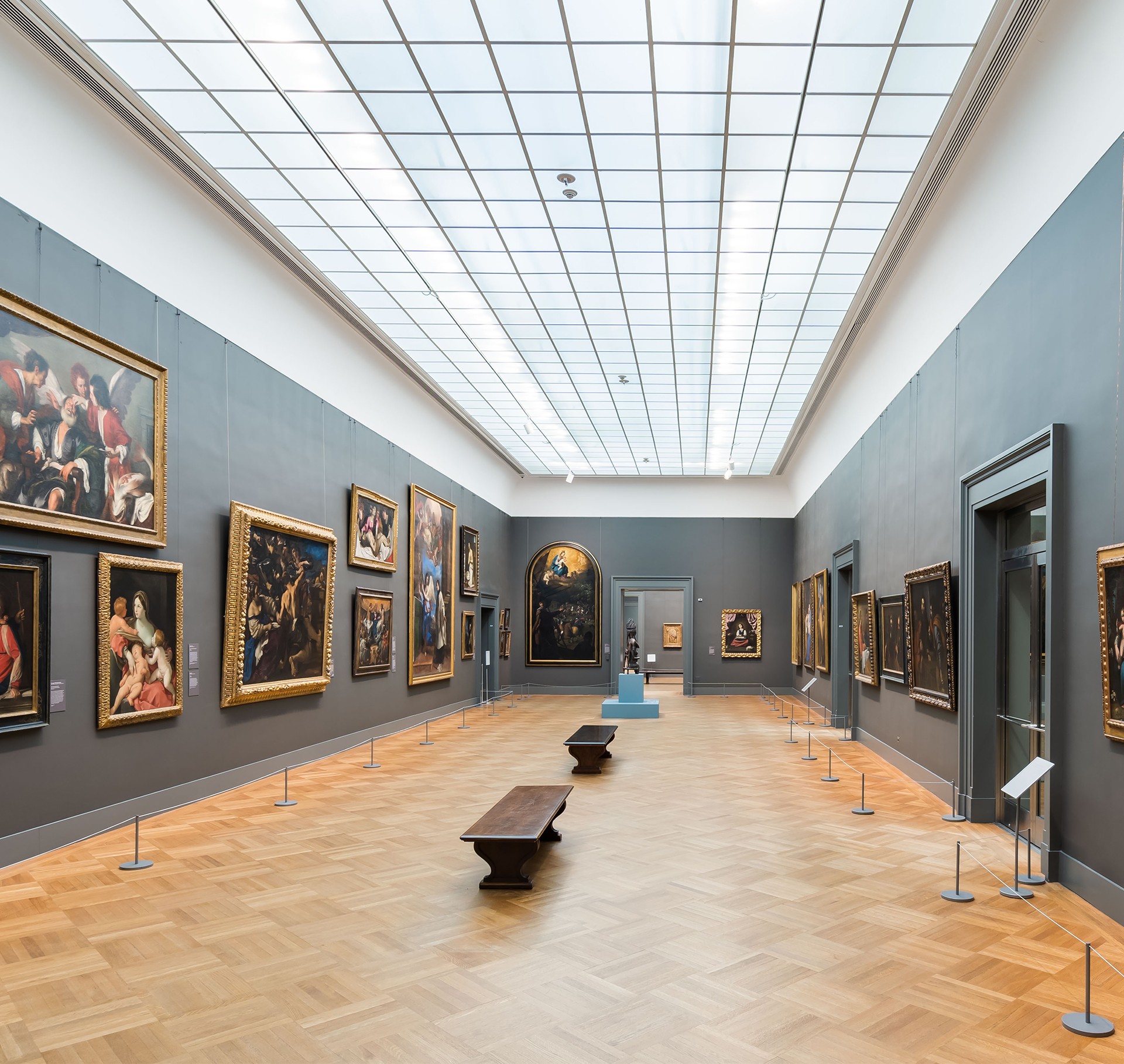 Modern Art Gallery Interior with Classic Paintings Displayed Modern art gallery interior with classic paintings on gray walls and wooden flooring.