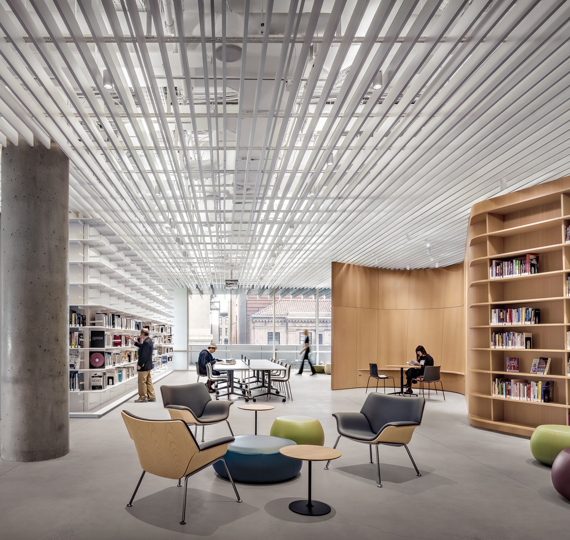 Modern library interior with seating and natural light Modern library interior with sleek seating, bookshelves, and people studying.