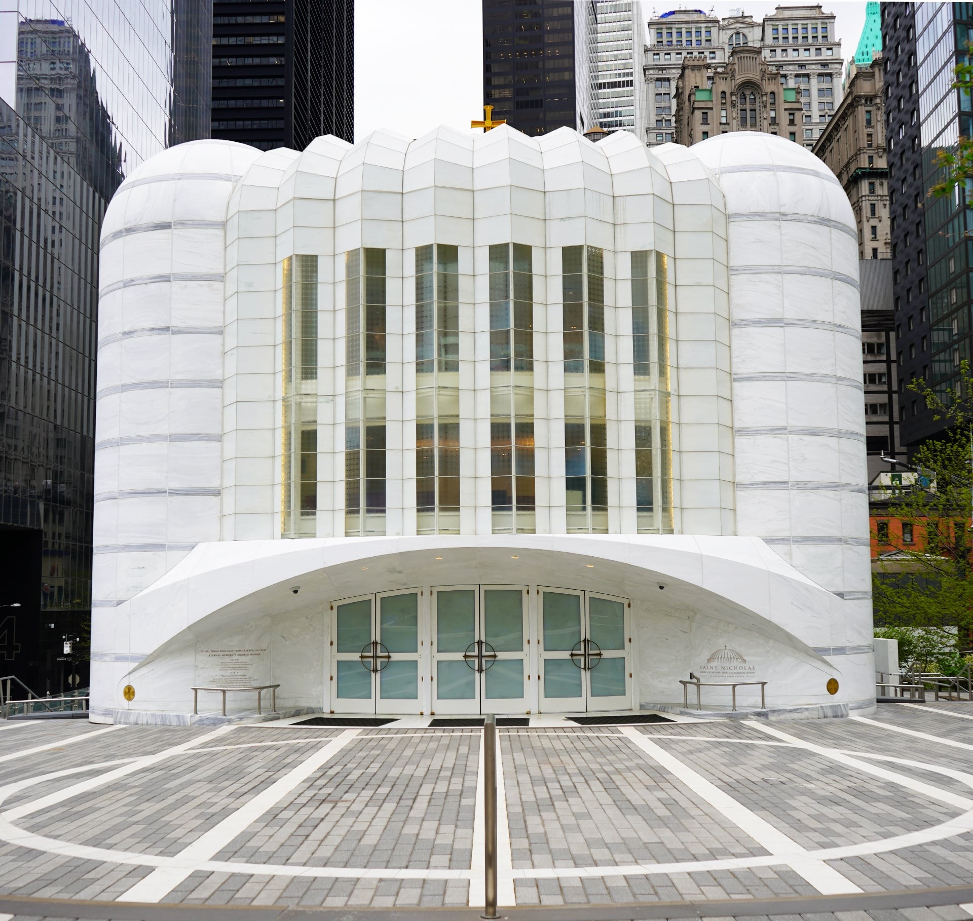 Modern White Church Facade Surrounded by Urban Skyscrapers Modern white church with curved roof and tall windows in an urban cityscape.
