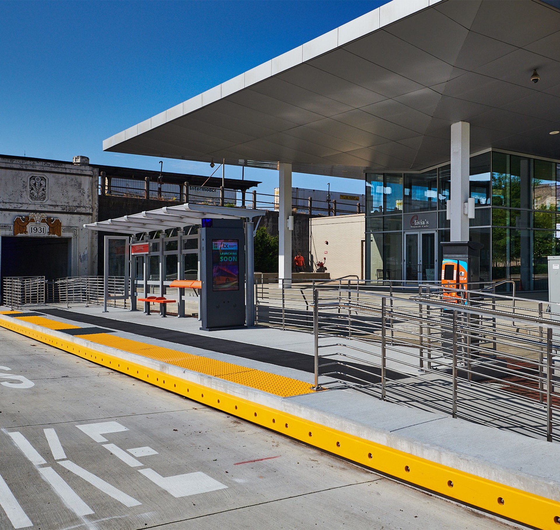 Modern Bus Stop Shelter with Clear Blue Sky and Accessibility Modern bus stop with shelter, benches, and clear blue sky in an urban setting.