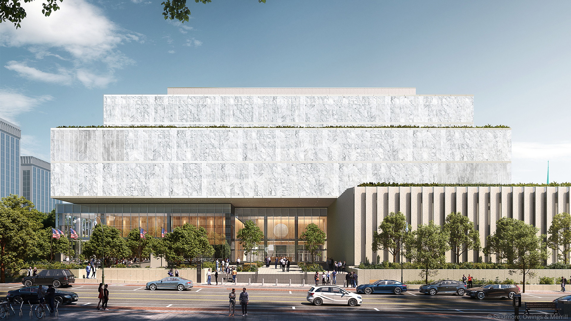 Modern government building with tiered white facade and trees along the street.