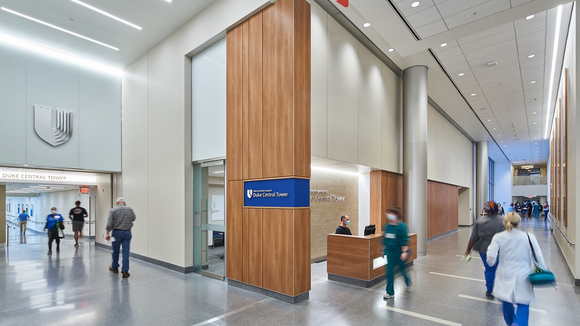 Modern hospital lobby with staff and patients near Duke Central Tower reception area.