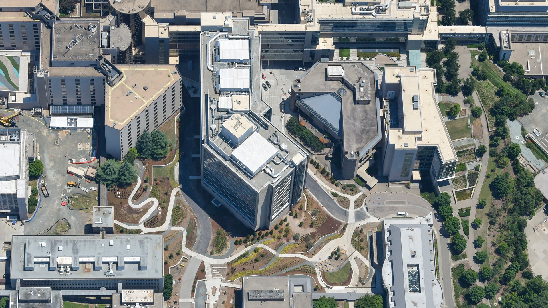 Aerial view of a modern urban complex with multiple buildings and landscaped paths.