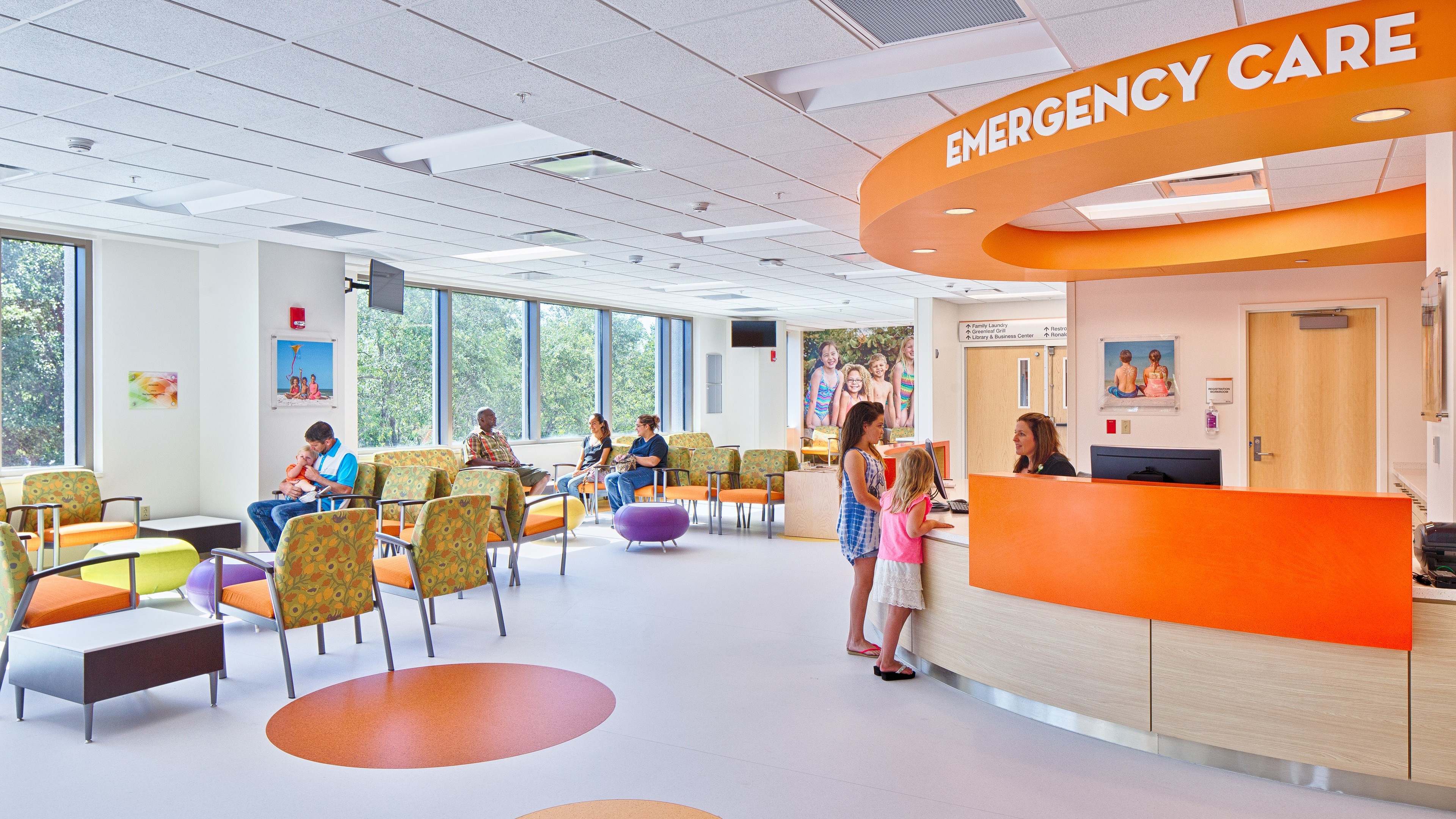 Bright, modern emergency care waiting room with families and colorful seating.