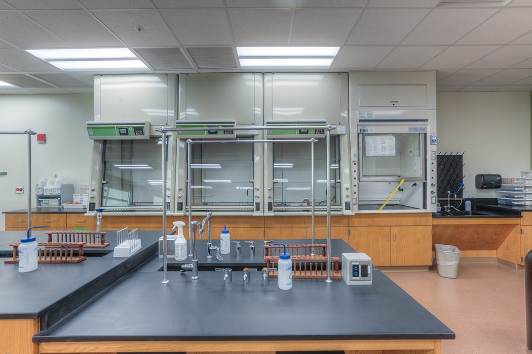 Modern laboratory with fume hoods, workstations, and equipment for scientific research.